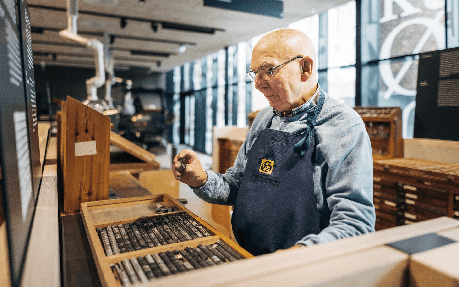 Master typesetter examining movable lead type